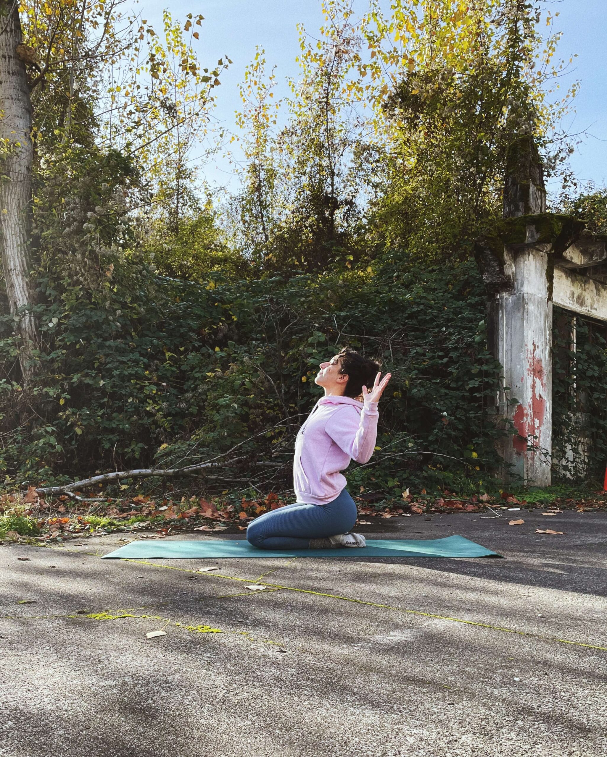 a sleep-deprived nurse doing yoga by some bushes